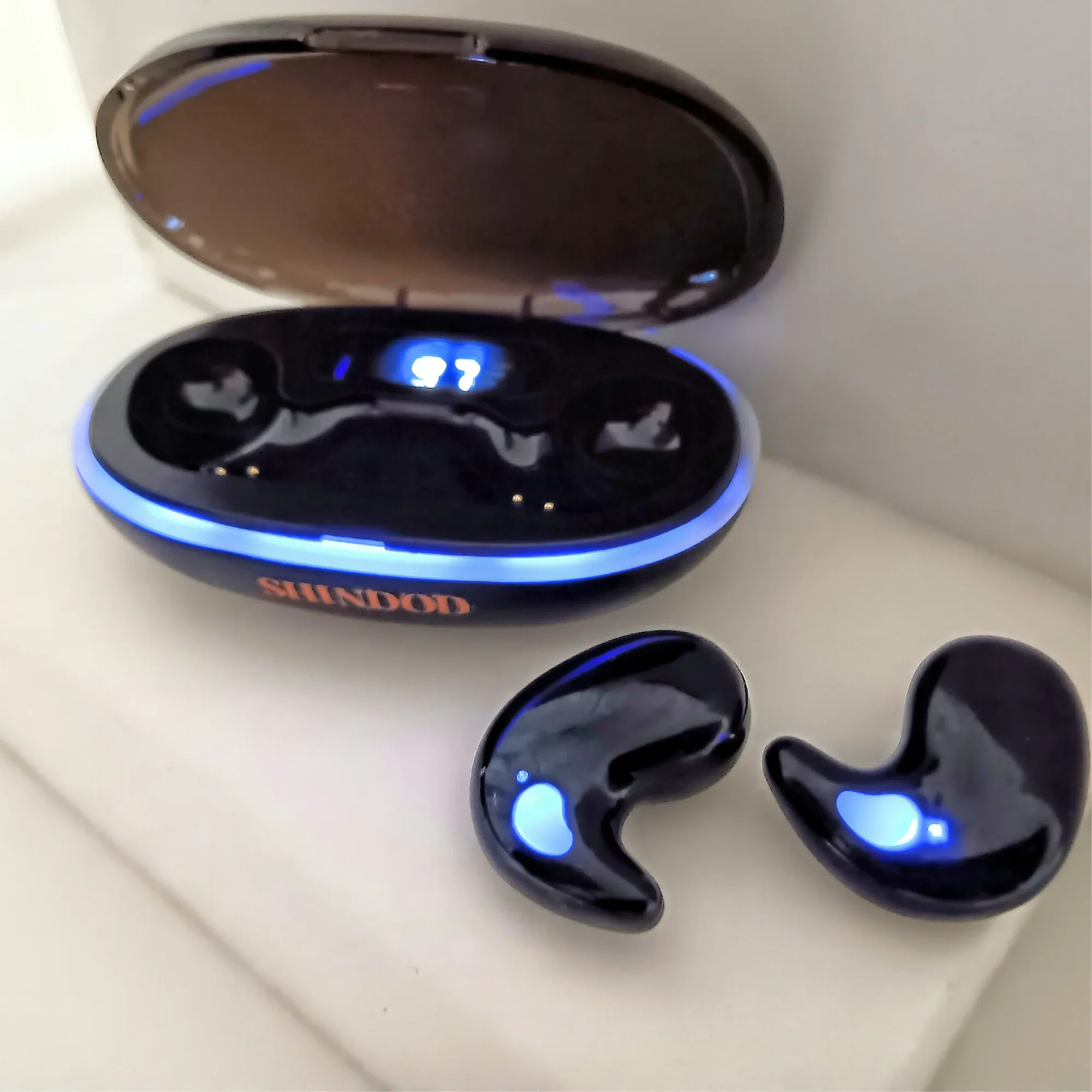 SHINDOD XC‑3 Ladecase geöffnet mit Anzeige und Ohrhörern davor – Bild zur Identifikation im Downloadkatalog